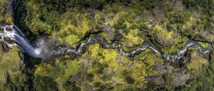 Aerial View of Iceland Waterfall and River Flowing Through Mossy Landscape Lush Greenery Dramatic Perspective