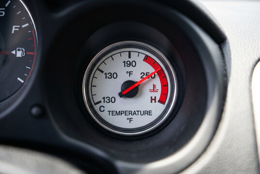 Car engine temperature gauge showing high reading on dashboard for overheating warning and vehicle maintenance indicator