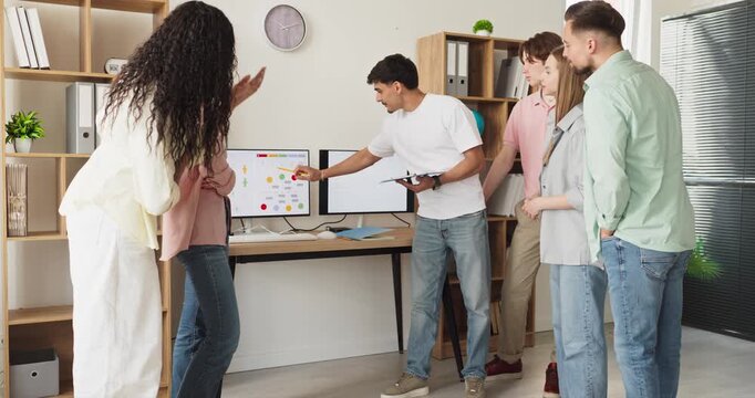 Students team meeting presentation in modern office. Group reviews charts as a presenter explains data, driving open collaboration on the project. Concept of teamwork and project planning.