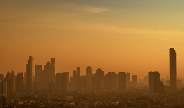 Air pollution. Smog and fine dust of pm2.5 covered city in the morning with orange sunrise sky. Cityscape with polluted air. Dirty environment. Urban toxic dust. Unhealthy air. Urban unhealthy living.
