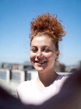 Point of view of a young redhead woman smiling and taking a selfie, first-person view