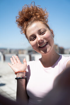 Point of view of a young redhead woman smiling and taking a selfie, first-person view