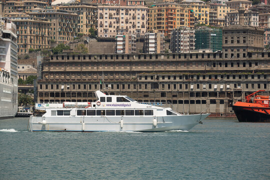 Exterior view of a tourist passenger cruise vessel moving around the Port of Genoa