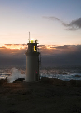 Lighthouse with keeper by stormy weather with big waves in the evening, Faro de Mux&iacute;a, Galicia, Costa da Morte, Spain, Europe. 