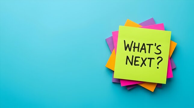 Neon yellow sticky note with Whats Next text written on it, stacked on colorful paper squares, positioned on a vibrant blue background of office desk