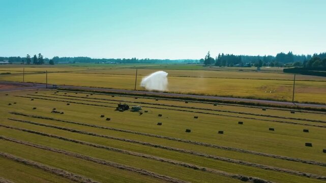 Epic cinematic drone shot of a modern tractor working across farmland in the British countryside during summer. Sweeping rural landscape showcasing precision farming, agricultural machinery and produc