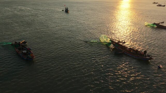 Vietnam, Da Nang Sunset Light Over Da Nang Fishing Nets And Boats, Golden Reflections On Water With Asian Fishermen Tending Nets And Silhouettes Creating Warm Evening Mood