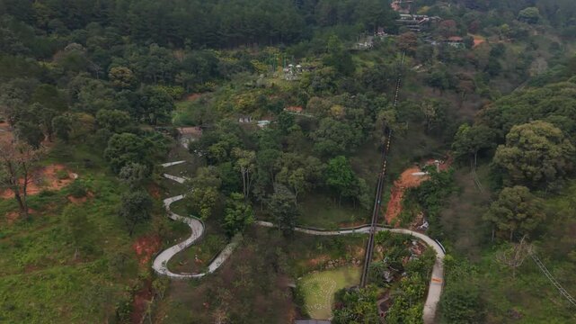 Vertical screen, Vietnam, Da Lat Corkscrew Route Traversing Flourishing Plant Life And Stunning Outdoor Scenery. Spiral Pathway Winding Through Flourishing Trees And Breathtaking Natural