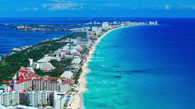 Aerial view of the Cancun Hotel Zone coastline, Quintana Roo, Mexico, deep-blue Caribbean Sea and turquoise shallows along the white-sand beach.