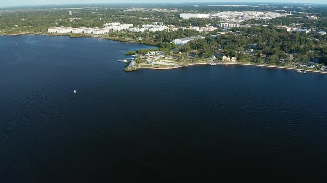 Wide aerial shot capturing a waterfront area with adjacent urban landscape. Ideal for urban development or geography studies.