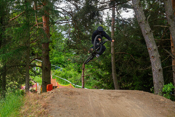 Mountain biker performing a stylish jump on a forest trail   Rider MTB wykonujący stylowy skok na leśnej trasie © Adrian White