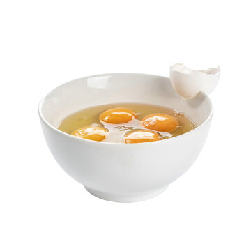 A white ceramic bowl containing several cracked raw eggs with golden yellow yolks and clear whites, with a broken egg shell resting on the rim