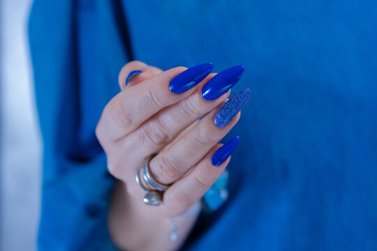 Woman's beautiful hand with long nails and bright blue manicure