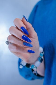 Woman's beautiful hand with long nails and bright blue manicure