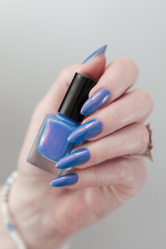 Woman's beautiful hand with long nails and light blue manicure 