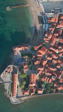 Top down drone shot revealing the beautiful old town of budva in montenegro. Red tiled roofs and historic buildings along the adriatic coast