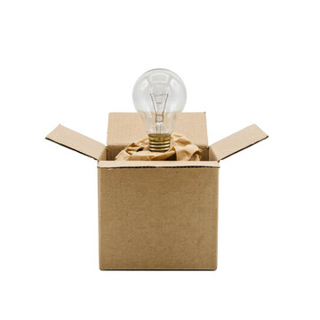 A clear glass light bulb sitting inside an open brown cardboard shipping box, surrounded by crumpled packing paper, isolated on white background
