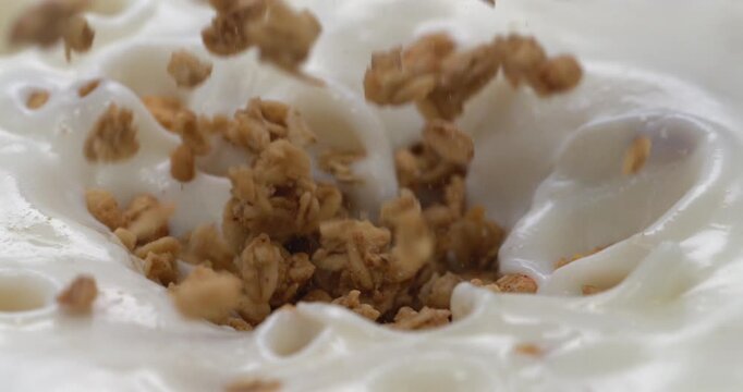 Granola falling into yogurt in super slow motion for breakfast cereal advertising
