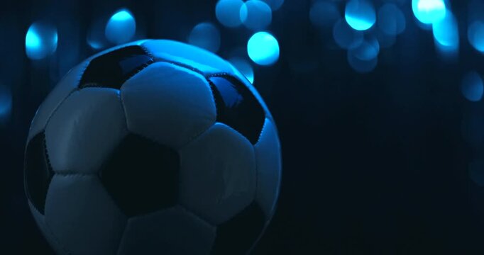 Rotating soccer ball close up on dark blue background