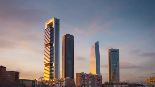 Time lapse of four modern skyscrapers in Madrid at twilight transition to night.