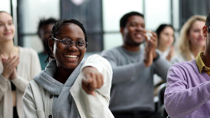 Obraz premium smiling african american woman pointing finger at camera.