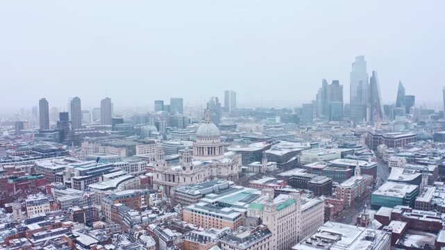Aerial view of snowy London city skyline featuring St Pauls Cathedral in winter.
