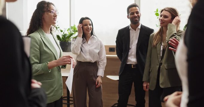 Team meeting leader presentation in business office. Diverse professionals collaborate in a modern workspace, sharing ideas and aligning goals for growth. Strong teamwork and leadership concept.