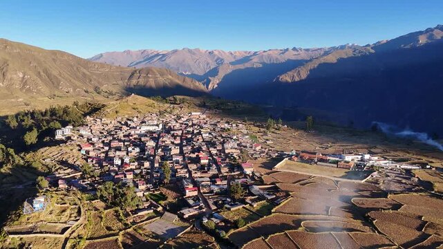 Wide aerial panorama of Cabanaconde town in the Colca Canyon, Peru, showing a rotating view of the village, agricultural terraces, and Andes mountains