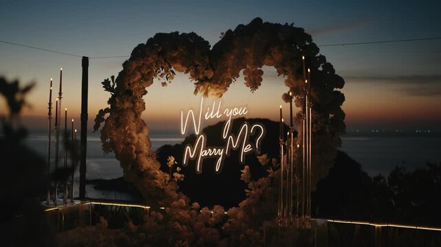 A stunning heart-shaped floral arch with a glowing "Will you marry me?" neon sign at sunset by the sea, capturing the ultimate romantic moment for marriage proposals and engagements.
