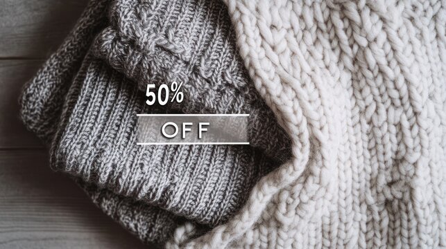 Folded gray knitted sweater on textured cream cable-knit fabric