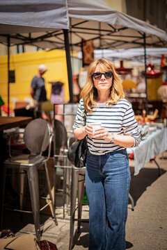 Blond haired mature woman walking at the flea market in an european city
