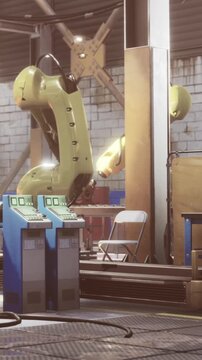 Two robotic arms are positioned in a factory. They are part of an automation system that runs various tasks. Tools and machines are nearby, and a chair is in the background.
