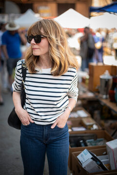Blond haired mature woman walking at the flea market in an european city