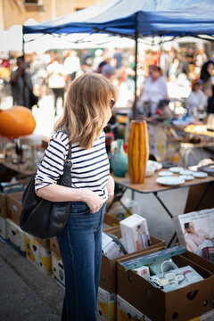Blond haired mature woman walking at the flea market in an european city