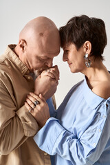 Fototapeta premium Senior couple sharing a tender moment in stylish outfits showing their deep affection