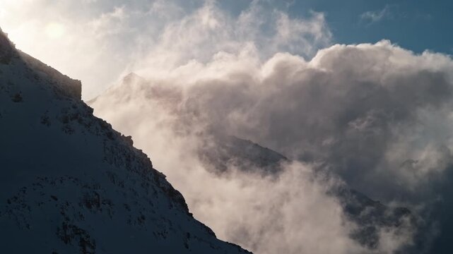 Dramatic clouds drifting between Mont Gel&eacute; and Bec des Rosses above Verbier, Switzerland. Fast moving alpine weather creates an atmospheric mountain landscape.