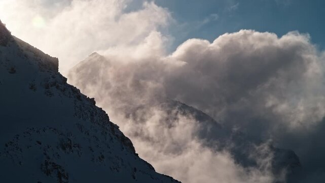 Dramatic clouds drifting between Mont Gel&eacute; and Bec des Rosses above Verbier, Switzerland. Fast moving alpine weather creates an atmospheric mountain landscape.
