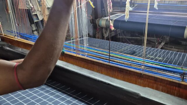 4k video of a handloom weaver in India working in his loom.