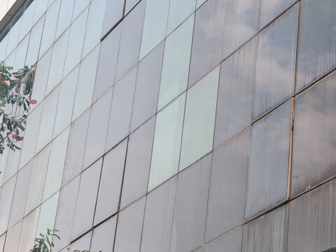 Modern architectural building facade with geometric metal and glass panels, clean contemporary design, urban structure, and abstract surface details for architecture and background concepts