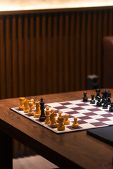Chessboard Strategizing: A close-up view of a wooden chessboard with an ongoing game, pieces meticulously arranged, inviting strategic thought and intellectual challenge. © andreas