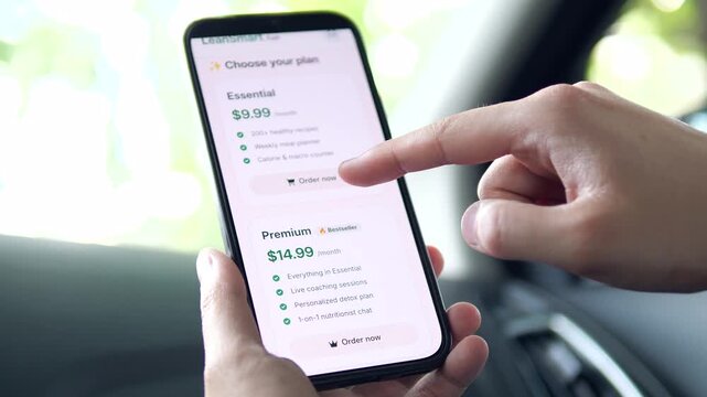User subscribing to a premium health plan on a smartphone. Close-up of app UI featuring meal plans and coaching. Perfect for wellness tech and digital economy stories. High-converting footage for