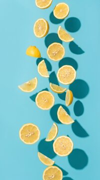 Falling fresh lemon slices on cyan blue background