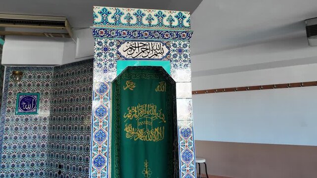 Mihrab in a modern mosque with traditional Iznik ceramic tiles and green fabric banner with Arabic calligraphy, Islamic design elements and architecture indoor