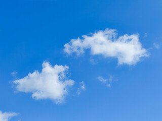 Sunny day with clear blue sky and soft cumulus clouds. Minimalist nature background for creative projects, travel inspiration, and environmental themes. High quality, crisp, bright atmosphere © Amin Rois