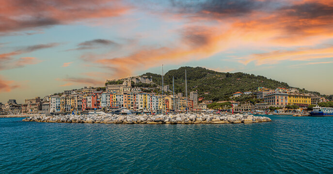 View from the sea of ​​the coast of the town of Portovenere, province of La Spezia, Italy, with a multitude of picturesque multicolored houses and the tourist port. In the background is Doria Castle.