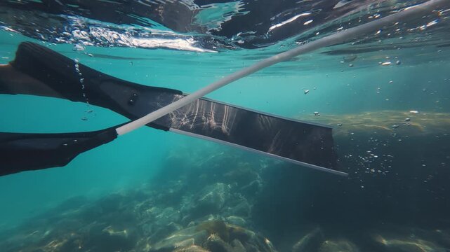 Person freediver swims slowly in the tropical sea with fins