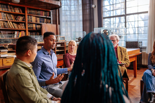 University students and professor discussing in library
