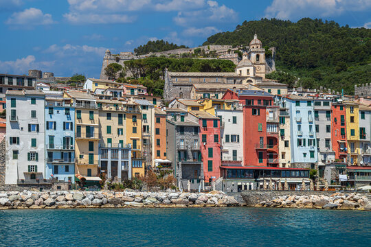 View from the sea of ​​the coast of the town of Portovenere, province of La Spezia, Italy, with a multitude of picturesque multicolored houses and the tourist port. In the background is Doria Castle.