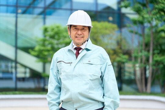作業着を着て立つアジア人男性