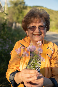 Elderly woman portrait with a bouquet of field flowers outdoor